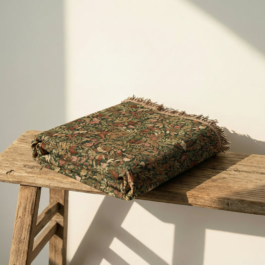 Botanical Field jacquard woven throw blanket folded on wooden stool – premium cotton tapestry blanket with botanical design for luxury home styling